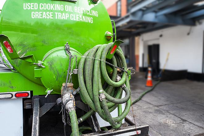 a technician pumping a grease trap in a commercial building in Waterford